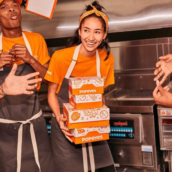 Person holding multiple popeyes chicken boxes